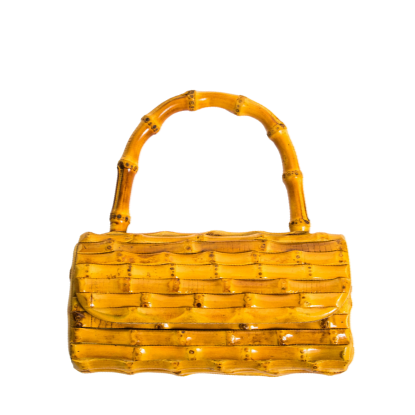 Yellow bamboo-style clutch with curved handles, styled with beach shells for a tropical summer vibe.